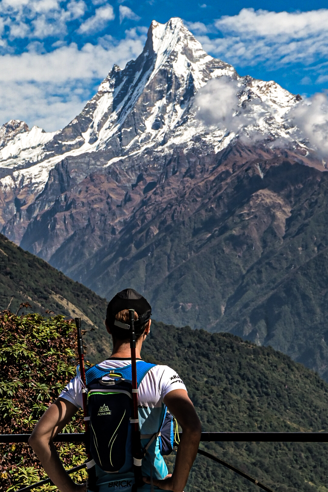 Trail runner looking up at the Machapuchare peak in the Himalayas, Nepal
